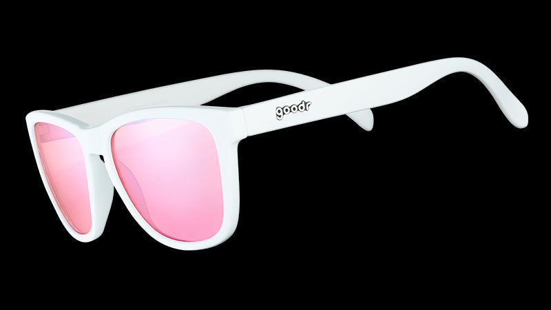 Vue de trois quarts d'angle de lunettes de soleil blanches de forme carrée avec des verres non réfléchissants teintés en rose.