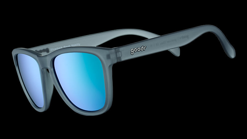 Vue de trois quarts d'angle de verres solaires de forme carrée avec une monture translucide grise et des lentilles réfléchissantes vertes.