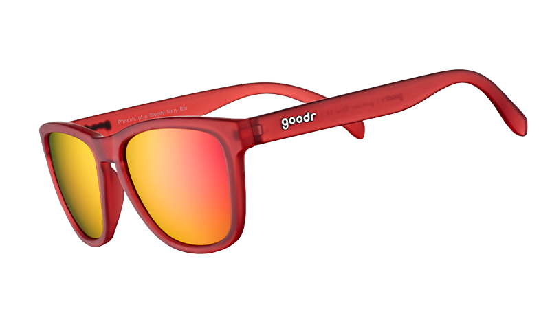 Vue de trois quarts d'angle de lunettes de soleil de forme carrée avec des montures translucides rouges et des verres réfléchissants rouges.