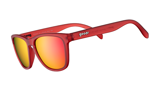 Vue de trois quarts d'angle de lunettes de soleil de forme carrée avec des montures translucides rouges et des verres réfléchissants rouges.